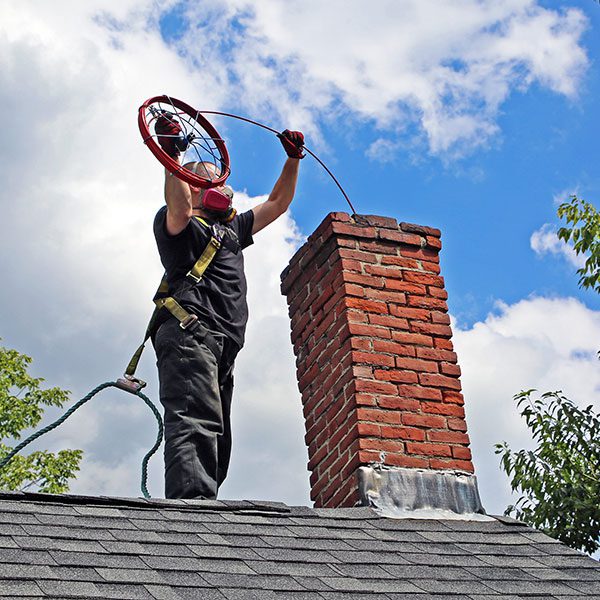 Chimney professional using rotary equipment to remove flue deposits